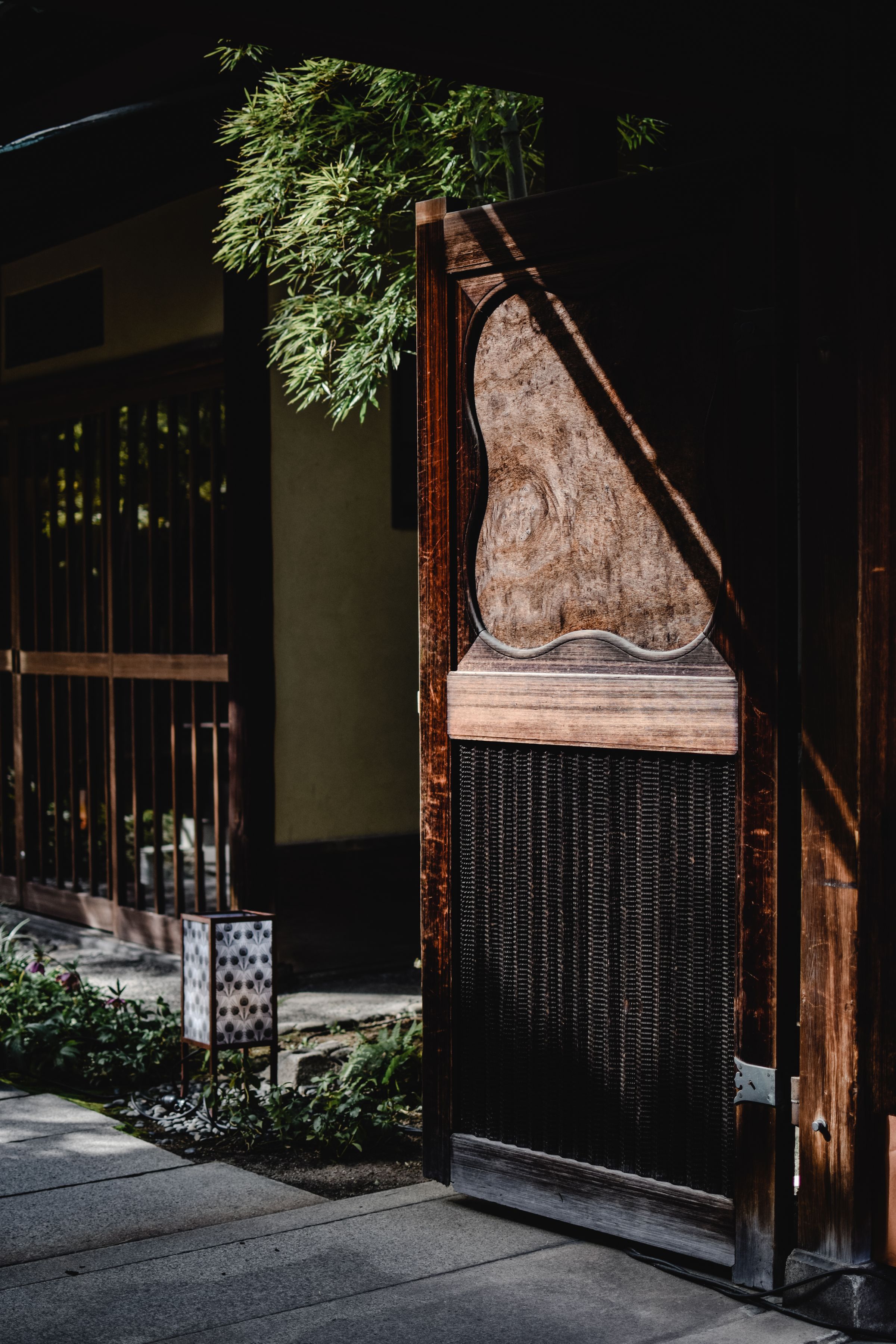 Entrada tradicional japonesa, vista através de uma porta de madeira.
